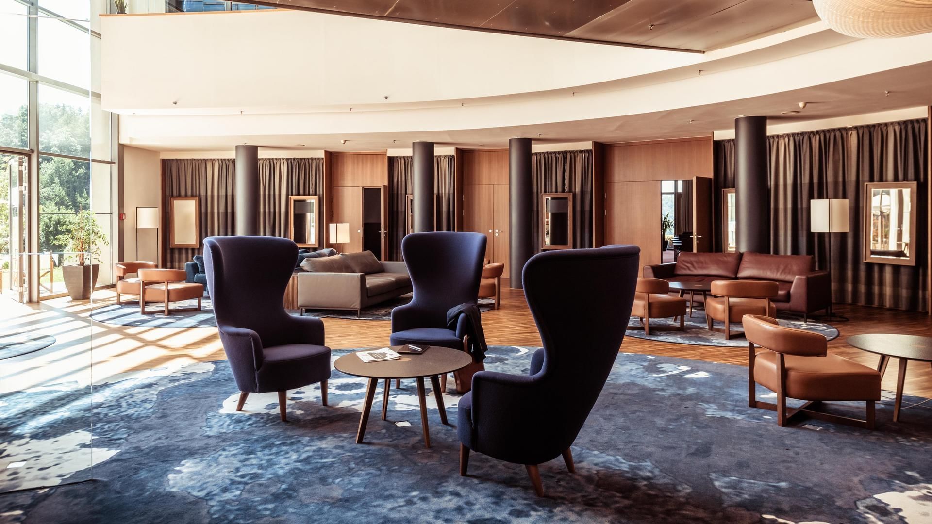 Eine stilvolle Hotellobby mit modernen Möbeln, großen Fenstern und einem offenen Raumdesign.
