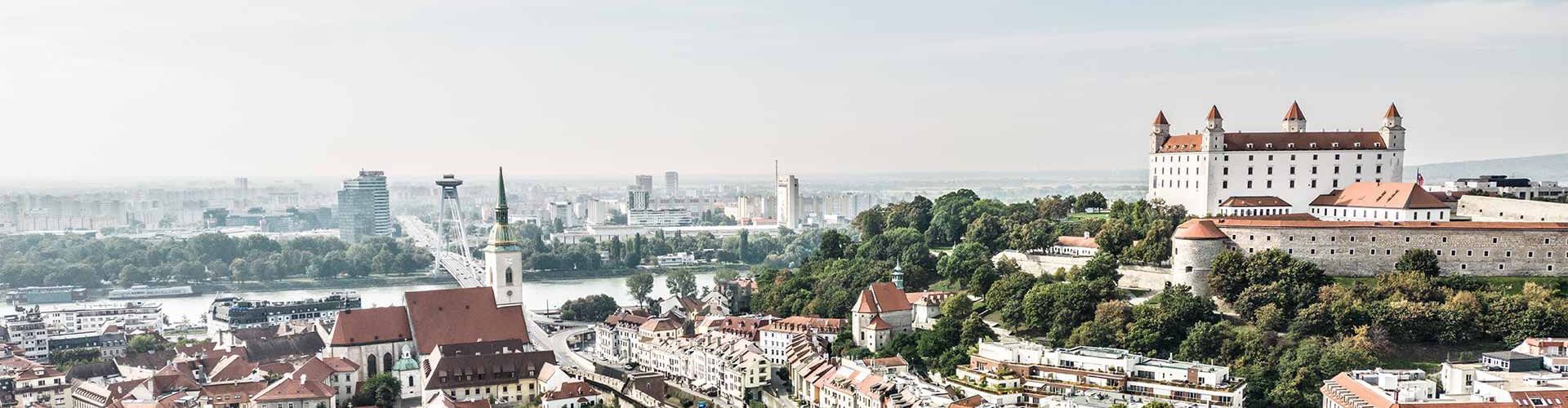 Luftaufnahme von Bratislava mit Burg, Donau und modernen Gebäuden.