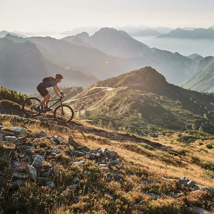 Radfahrer in den Bergen auf einem Mountainbike während des Sonnenuntergangs mit einer schönen Landschaft.