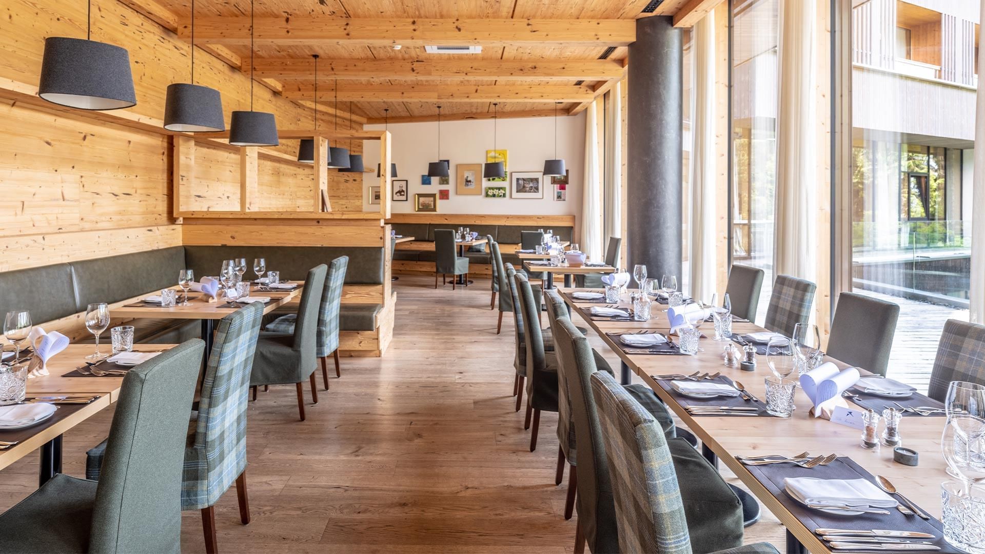 Holzrestaurant mit gedeckten Tischen, eleganten Stühlen und warmen Holztönen.