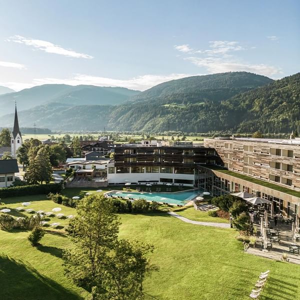 Luftaufnahme eines modernen Hotels mit Pool und umgebenden Bergen und Landschaft.