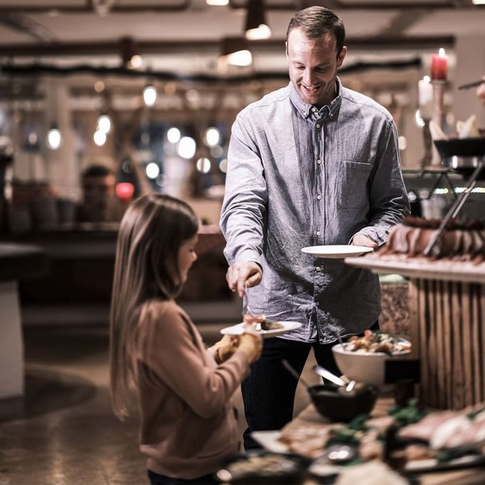 Ein Mann serviert einer jungen Frau Essen in einem Buffet-Restaurant.